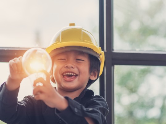 Een kind houdt een heldere gloeilamp vast
