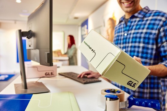 GLS työntekijä pitää pakettia kädesään